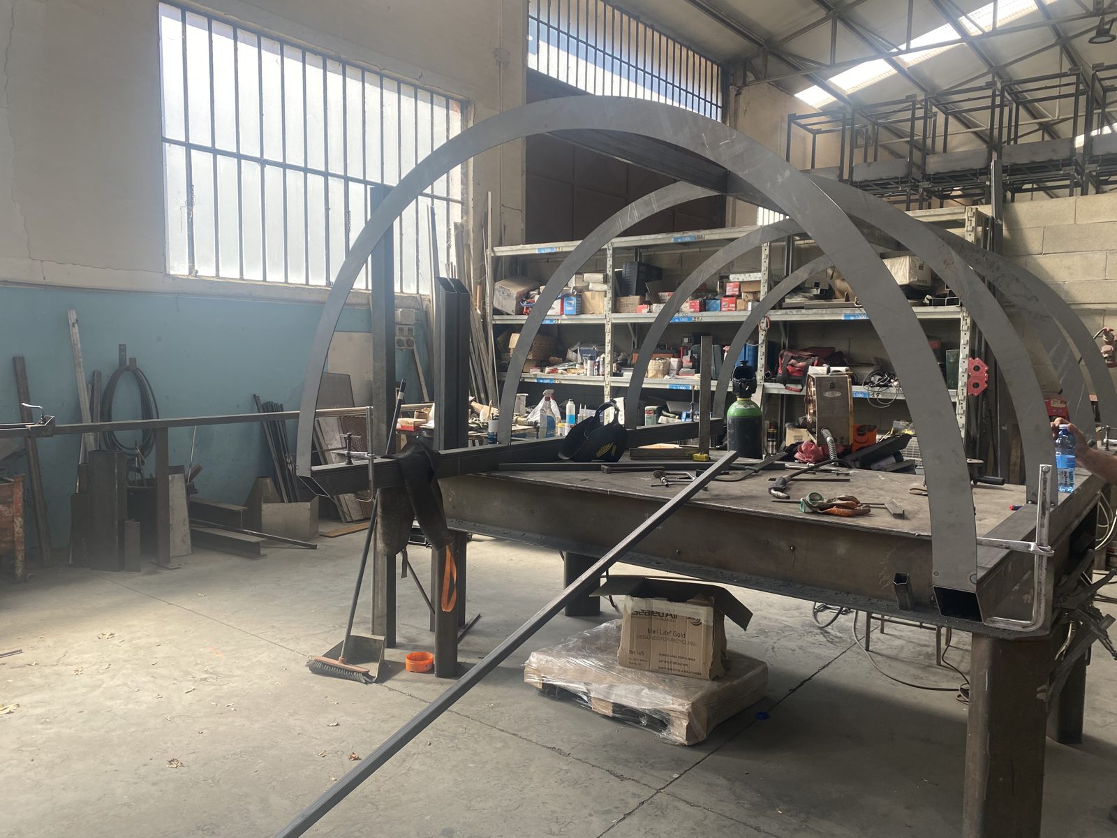 L'officina Fida con gli archi in metallo di una vetrata in lavorazione sul banco